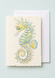 Opal the Seahorse 5x7 deckled-edge greeting card showing blue, gold, and opalescent seahorse with a white envelope